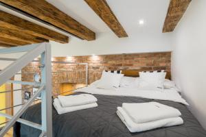 クラクフにあるCracowapart Loft Gertrudaのレンガの壁に大きなベッドが備わるベッドルーム1室が備わります。