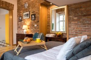 a bedroom with a bed with a tray of fruit on a table at Cracowapart Loft Gertruda in Kraków