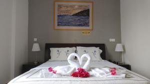 dos toallas de cisne están sentadas en una cama en Hotel Galaxidi en Galaxidhion