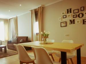 una mesa de comedor con sillas y un jarrón de flores en Apartamentos El Valle, en Bubaces