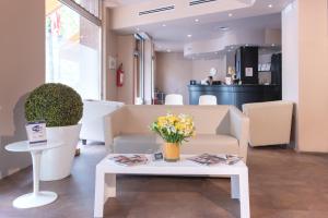 uma sala de estar com uma mesa e flores em Hotel Oro Blu em Milão