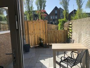 a patio with a table and chairs and a fence at Logies het Noordwestertje in Den Burg