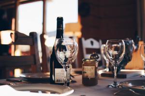 a bottle of wine and two wine glasses on a table at La Bicok EcoLodge in Mindo