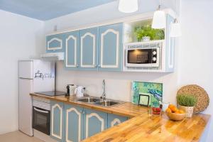 a kitchen with blue cabinets and a wooden counter top at Hola ola Bajamar in Bajamar