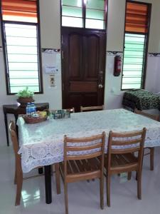 mesa de comedor con 2 sillas y mesa con mantel blanco en Anjung Nor Muslim Homestay en Dungun