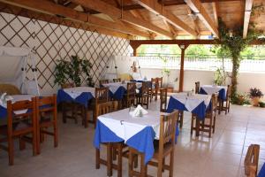 a restaurant with tables and chairs with blue napkins on them at Hotel Galaxidi in Galaxidi