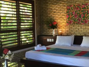 ein Schlafzimmer mit einem Bett und einer Ziegelwand in der Unterkunft Hotel Casablanca in Pipa