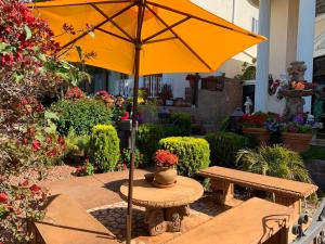 Entire Second Flr - Santa Monica Luxury Roman Villa في لوس أنجلوس: وجود مظلة صفراء على طاولة في حديقة