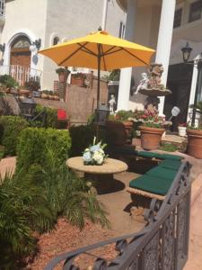 a patio with a table and an umbrella at Entire Second Flr - Santa Monica Luxury Roman Villa in Los Angeles