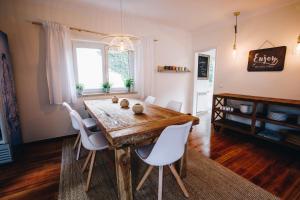 comedor con mesa de madera y sillas blancas en Sunny Soul, en Malveira da Serra