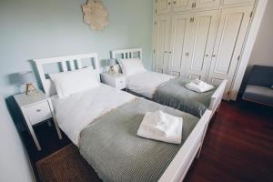 a bedroom with two beds and a chair at Sunny Soul in Malveira da Serra +20 photos