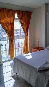 a bedroom with a bed and a large window at HOTEL NES in Maicao