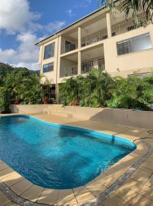 a swimming pool in front of a building at Island Views in Airlie Beach