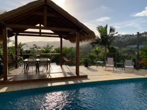 a patio with a table and chairs next to a swimming pool at Island Views in Airlie Beach