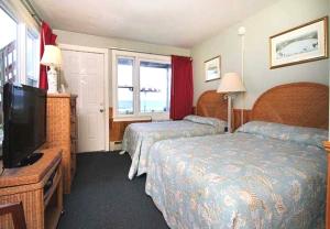 a hotel room with two beds and a flat screen tv at The Skylark Beach Inn in Old Orchard Beach