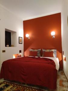 sypialnia z dużym łóżkiem z czerwonym zagłówkiem w obiekcie Riad BILKIS w Marakeszu