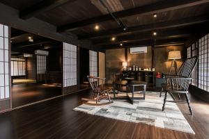 a living room with a table and chairs at EN Takeda Castle Town Hotel in Asago