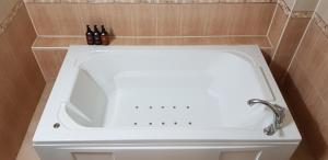 La salle de bains est pourvue d'une baignoire blanche. dans l'établissement Incheon Airport Hotel Queen, à Incheon