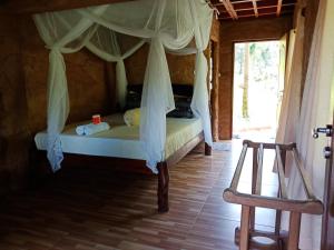 a bedroom with a bed with a canopy at On The Rocks Bungalows, Restaurant and Jungle Trekking Tours in Bukit Lawang