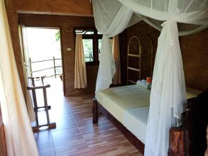 a bedroom with a bed and a ladder in it at On The Rocks Bungalows, Restaurant and Jungle Trekking Tours in Bukit Lawang