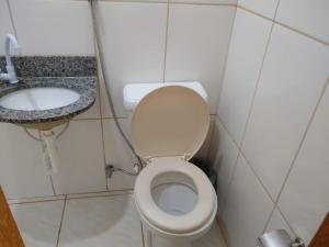 a small bathroom with a toilet and a sink at JACARANDÁ CHALÉS em SÃO JOSÉ DA SERRA MG in Jaboticatubas