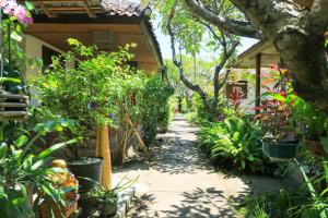a garden path in a house with plants at Mertha Jati Hotel in Kuta