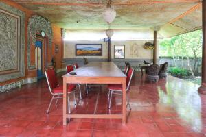 a dining room with a wooden table and chairs at Mertha Jati Hotel in Kuta