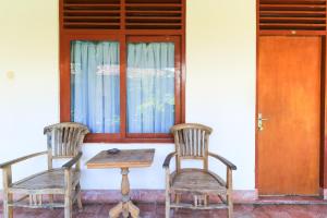 two chairs and a table in front of a door at Mertha Jati Hotel in Kuta +20 photos