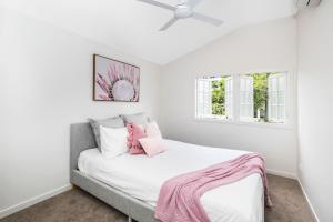 ein Schlafzimmer mit einem Bett mit einer rosa Decke darauf in der Unterkunft Park Avenue Terrace House Sleeps 9 in Brisbane