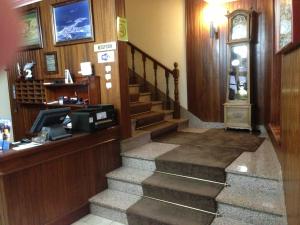 a lobby with a staircase and a cash register at Hotel O Castelo in Cervo