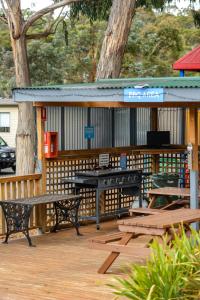 a picnic table and benches on a wooden deck at Discovery Parks - Hobart in Hobart