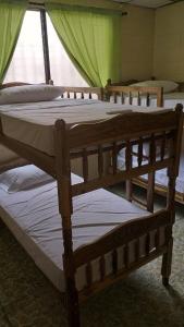 eine Gruppe von 3 Betten in einem Zimmer in der Unterkunft Hostal Doña Marta in San Salvador