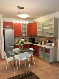 ボローニャにあるLa Casa di Manoloのキッチン(赤いキャビネット、テーブル、椅子付)