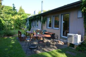 eine Terrasse mit einem Tisch, Stühlen und einem Hund in der Unterkunft Quartier SansSouci Hostel in Potsdam