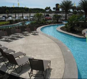 a swimming pool with chairs and tables in a resort at Seven Clans Hotel at Coushatta in Kinder