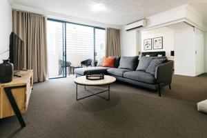 a living room with a couch and a table at Gabba Central Apartments in Brisbane