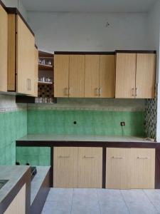 eine große Küche mit Holzschränken und grünen Fliesen in der Unterkunft Pildacil in Garut
