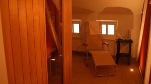 a room with a chair and a table and window at LandHotel Lönskrug in Hellental