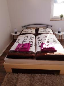 a bed with two blankets and pillows on it at Ferienwohnung ,,Zum Posthaus" in Kolkwitz