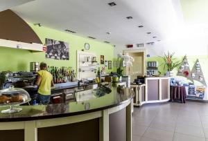 a man standing at a counter in a kitchen at Hotel Lauro in Gravedona