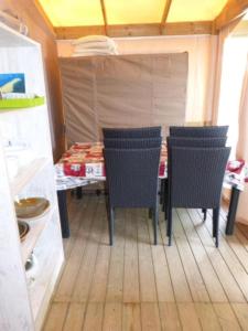 une salle à manger avec une table et des chaises dans une cuisine dans l'établissement Camping Routes du Monde ATC La Hume-Arcachon, à Gujan-Mestras