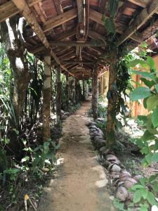 a wooden pergola over a path in a garden at Deniyaya National backpackers hostel in Deniyaya