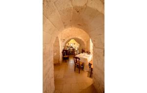 a large room with a stone wall and a clock on the wall at Masseria Chiancone Torricella in Martina Franca