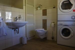 ein Badezimmer mit einem Waschbecken und einer Waschmaschine in der Unterkunft Alte Bäckerei in Monschau