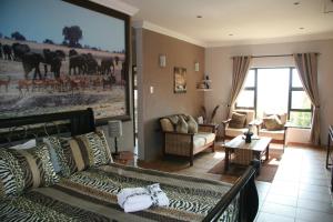 a living room with a couch and a large painting at Ponciana Superior Guesthouse in Hartbeespoort
