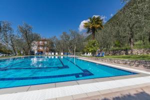 a large swimming pool with blue water at Garnì Casa Rabagno in Malcesine