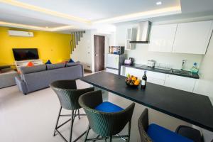 una cucina e un soggiorno con tavolo e sedie di The Pearl Luxury Pool Villas a Ko Chang