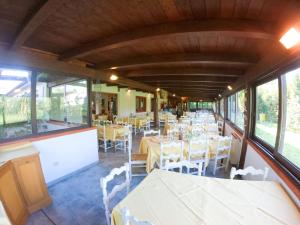 a dining room with white tables and white chairs at Hotel Santa Caterina in Marina di Campo