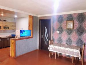 una sala da pranzo con un tavolo e una TV a parete di wine valley a Udabno