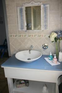 a bathroom counter with a white sink and a mirror at Ponciana Superior Guesthouse in Hartbeespoort
